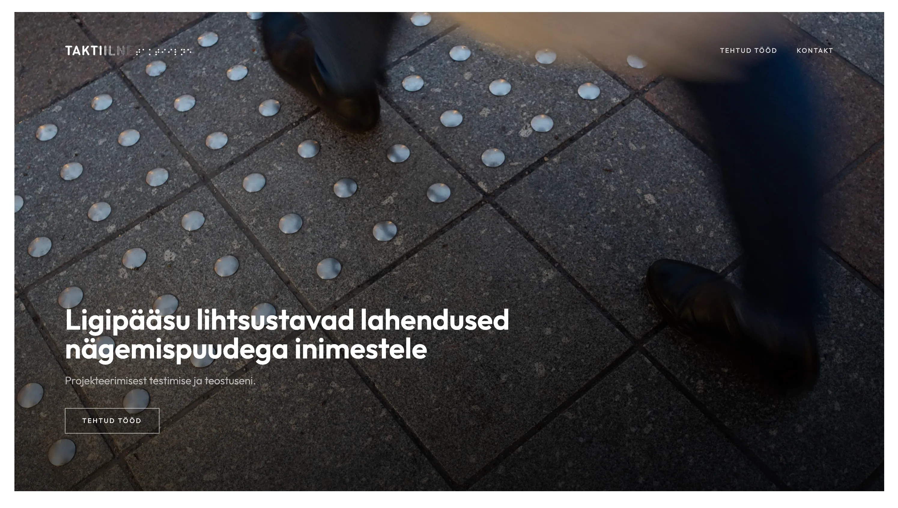 taktiilne.ee avaleht: foto jalge all olevast taktiilsest sillutisest, millele on asetatud juhtlause.
